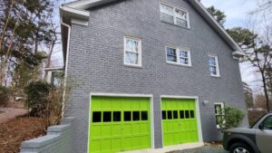 gray siding with exterior painting and green garage doors