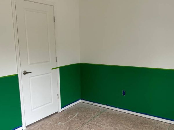 room with white and green walls with drywall