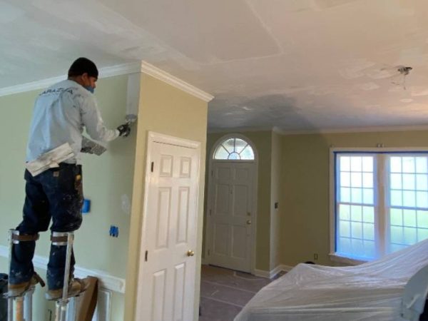 professional performing drywall installation task in living room