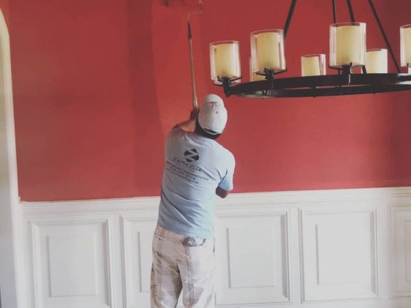 Zurazua professional in blue shirt painting wall red after dry wall installation
