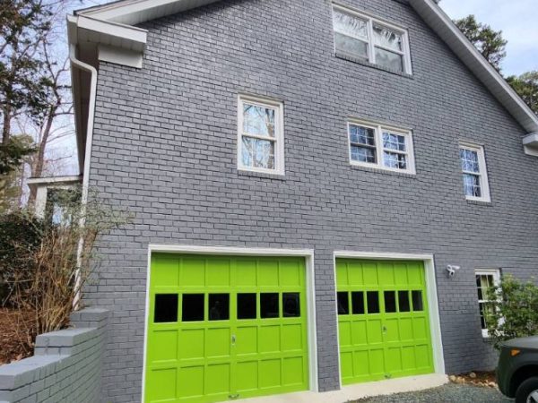 gray siding with exterior painting and green garage doors